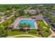 Aerial shot of a community pool with palm trees and manicured landscaping at 1254 Spartanburg Way, The Villages, FL 32162