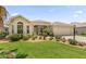 Charming single-story home with manicured front yard and attached garage, framed by beautiful landscaping under a sunny sky at 1254 Spartanburg Way, The Villages, FL 32162