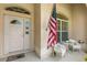 Cozy front porch seating area with an American flag displayed near the front door at 1254 Spartanburg Way, The Villages, FL 32162