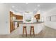 Well-lit kitchen featuring wood cabinetry, appliances, breakfast bar, and a cozy breakfast nook by the windows at 1254 Spartanburg Way, The Villages, FL 32162