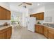 Bright kitchen features wooden cabinets, modern appliances, and an adjacent breakfast nook with a view at 1254 Spartanburg Way, The Villages, FL 32162