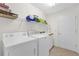 Well-lit laundry room with washer, dryer, utility sink, and storage at 1254 Spartanburg Way, The Villages, FL 32162