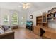 Comfortable living area features a ceiling fan, hardwood floors, and a built-in wooden entertainment center at 1254 Spartanburg Way, The Villages, FL 32162