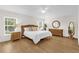 Bright main bedroom with hardwood floors, ceiling fan, wicker accents and lots of natural light at 1254 Spartanburg Way, The Villages, FL 32162