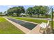 Shuffleboard court with benches and manicured lawn at a community amenity at 1254 Spartanburg Way, The Villages, FL 32162