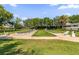 Community shuffleboard courts surrounded by lush landscaping and shaded seating areas at 1254 Spartanburg Way, The Villages, FL 32162