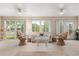 Bright sunroom features stylish furnishings, ceiling fans, and large windows for natural light at 1254 Spartanburg Way, The Villages, FL 32162