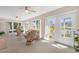 Bright sunroom featuring stylish furnishings, ceiling fans, and large windows and doors at 1254 Spartanburg Way, The Villages, FL 32162