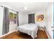 Cozy bedroom featuring hardwood floors, a ceiling fan, and a window with curtains at 131 N Central Ave, Apopka, FL 32703