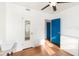 Bright bedroom with blue doors, light colored walls, and wood floors at 131 N Central Ave, Apopka, FL 32703