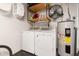 Functional laundry room with washer, dryer, shelving, and a hot water heater at 131 N Central Ave, Apopka, FL 32703