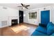 Cozy living room with a fireplace, hardwood floors, and natural light from the window at 131 N Central Ave, Apopka, FL 32703