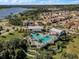 Aerial view of a community pool surrounded by lush landscaping and colorful homes under a blue sky at 1378 Roxy Ln, Winter Garden, FL 34787