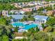Aerial view of a sparkling community pool surrounded by lush greenery and colorful residences at 1378 Roxy Ln, Winter Garden, FL 34787