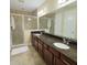 Bathroom featuring double sinks, granite countertops, and a glass-enclosed shower at 14164 Swanley St, Orlando, FL 32832