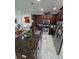 A well-equipped kitchen features an island with granite countertop, stainless steel appliances, and wood cabinetry at 14164 Swanley St, Orlando, FL 32832