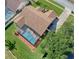 Aerial view of a home with a brown roof, screened pool, and well-manicured landscaping at 14322 Pine Cone Trl, Clermont, FL 34711
