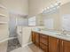 Bathroom features a dual vanity, shower, and bathtub with tiled floors and neutral paint at 14322 Pine Cone Trl, Clermont, FL 34711