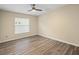Bright bedroom with wood floors, ceiling fan, and window with blinds providing plenty of natural light at 14322 Pine Cone Trl, Clermont, FL 34711