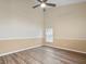 Comfortable bedroom with wood floors, ceiling fan, and a window with blinds for ample natural light at 14322 Pine Cone Trl, Clermont, FL 34711