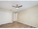 Bedroom featuring wood floors, a ceiling fan, closet, and an open doorway leading to another room at 14322 Pine Cone Trl, Clermont, FL 34711