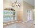 Light-filled dining area with tile floors, modern lighting, and views of the pool through a large window at 14322 Pine Cone Trl, Clermont, FL 34711