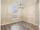 Bright dining room featuring wood floors, modern light fixture, and a large window with natural light at 14322 Pine Cone Trl, Clermont, FL 34711