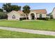 Charming one-story home with a well-maintained lawn, mature landscaping, and welcoming curb appeal at 14322 Pine Cone Trl, Clermont, FL 34711