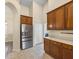 Bright kitchen features stainless steel refrigerator, wood cabinetry, and tiled flooring at 14322 Pine Cone Trl, Clermont, FL 34711