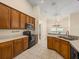 The kitchen is equipped with black appliances, wood cabinetry and ample counter space at 14322 Pine Cone Trl, Clermont, FL 34711