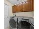 Laundry area features modern appliances, overhead storage and tile flooring at 14322 Pine Cone Trl, Clermont, FL 34711