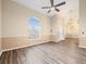 Bright living area with wood floors, arched window, and high ceilings with decorative pendant lighting at 14322 Pine Cone Trl, Clermont, FL 34711