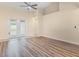 Bright living room with wood floors, ceiling fan, and glass doors leading to the outside at 14322 Pine Cone Trl, Clermont, FL 34711