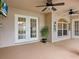 Covered patio has a ceiling fan, a large window, and a sliding glass door at 14322 Pine Cone Trl, Clermont, FL 34711