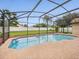 Screened-in pool area with refreshing blue water and ample space for relaxation and entertainment in a backyard setting at 14322 Pine Cone Trl, Clermont, FL 34711