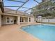 The screened pool area is ideal for outdoor entertaining with a covered porch and view of the backyard at 14322 Pine Cone Trl, Clermont, FL 34711