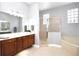 A relaxing bathroom with a glass shower, soaking tub, and wood cabinets at 1441 Foxtail Ct, Lake Mary, FL 32746