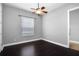 This bedroom offers dark wood floors, neutral walls, ceiling fan and a window with wood blinds at 1441 Foxtail Ct, Lake Mary, FL 32746