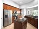 Kitchen featuring wood cabinetry, stainless steel appliances, granite countertops, and a functional island at 1441 Foxtail Ct, Lake Mary, FL 32746