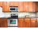 Kitchen showcasing wood cabinetry, stainless steel appliances, and a tiled backsplash for a modern touch at 1441 Foxtail Ct, Lake Mary, FL 32746