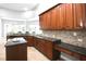 Kitchen featuring wood cabinetry, stainless steel appliances, granite countertops, and tile backsplash at 1441 Foxtail Ct, Lake Mary, FL 32746