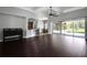 Open-concept living room featuring dark wood floors, access to the lanai, and a breakfast bar at 1441 Foxtail Ct, Lake Mary, FL 32746