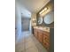 Bright bathroom featuring double sinks, wood cabinets, modern lighting, and walk-in shower with tiled walls at 1470 Daniels Cove Dr, Winter Garden, FL 34787