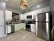 Well-lit kitchen featuring stainless appliances, white cabinets, mosaic backsplash, and tiled floor at 1470 Daniels Cove Dr, Winter Garden, FL 34787
