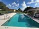 Community pool with lounge chairs surrounded by a black fence on a partly cloudy day at 1470 Daniels Cove Dr, Winter Garden, FL 34787