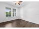 A bright bedroom featuring wood flooring, a ceiling fan, and two windows with blinds at 15500 Fountain Cove Ct, Winter Garden, FL 34787