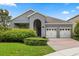 Charming home exterior with a well-manicured lawn and a two-car garage, all framed by vibrant landscaping at 15500 Fountain Cove Ct, Winter Garden, FL 34787