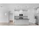 Modern white kitchen with stainless steel appliances, granite countertops and center island at 15500 Fountain Cove Ct, Winter Garden, FL 34787