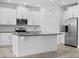 Modern white kitchen with stainless steel appliances, granite countertops and center island at 15500 Fountain Cove Ct, Winter Garden, FL 34787