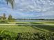 Scenic lake view showcasing a lush green lawn, clear water, and distant homes at 15500 Fountain Cove Ct, Winter Garden, FL 34787